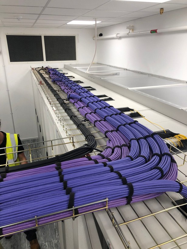 Cable bundles routed along tray above the racks