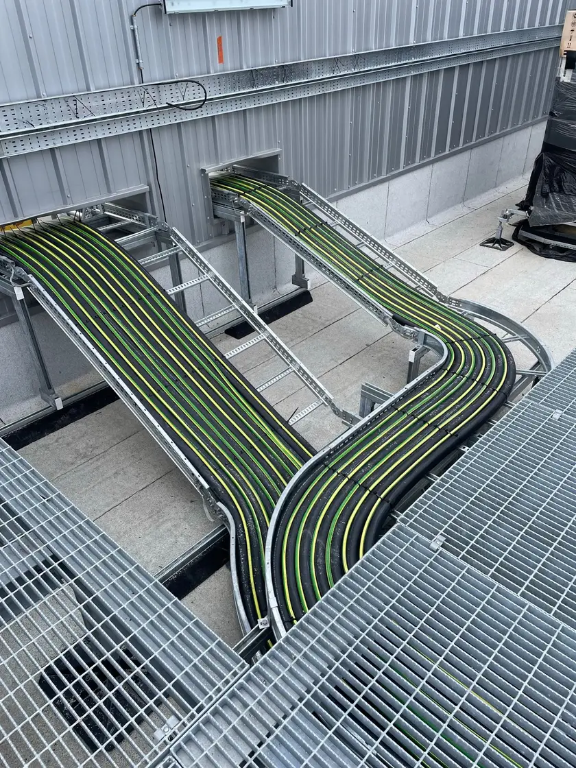 Power cabling dressed in sweeping runs along a ladder rack