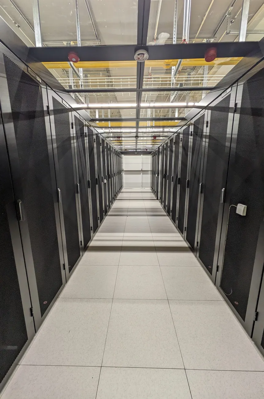 Long cold aisle between rows of black racks