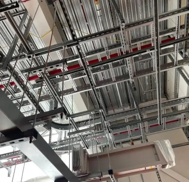 Overhead steel containment and cable trays below the ceiling