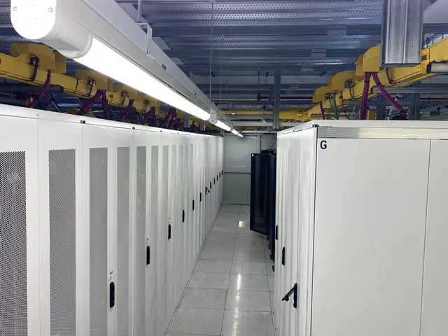 A white cabinet aisle mid-installation with cable trays overhead