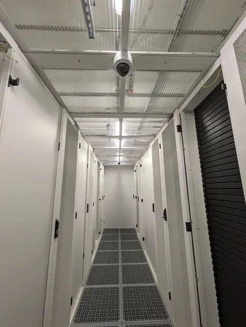 A white cabinet aisle with perforated floor tiles