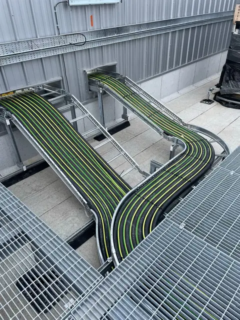Green power cables sweeping across floor grating