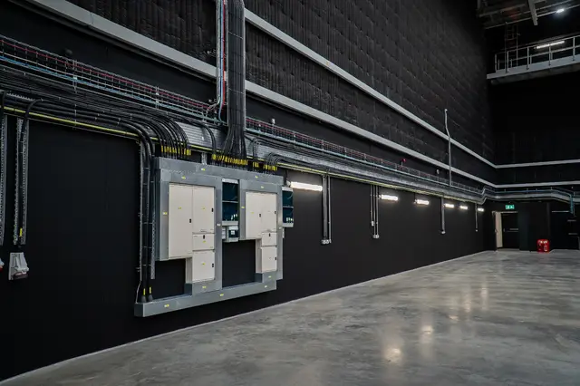 Power distribution boards along a dark hall wall