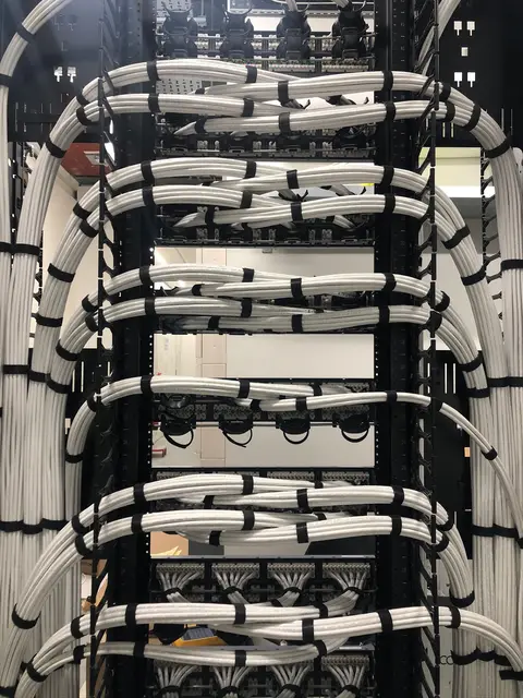 White cable looms dressed at the rear of a rack